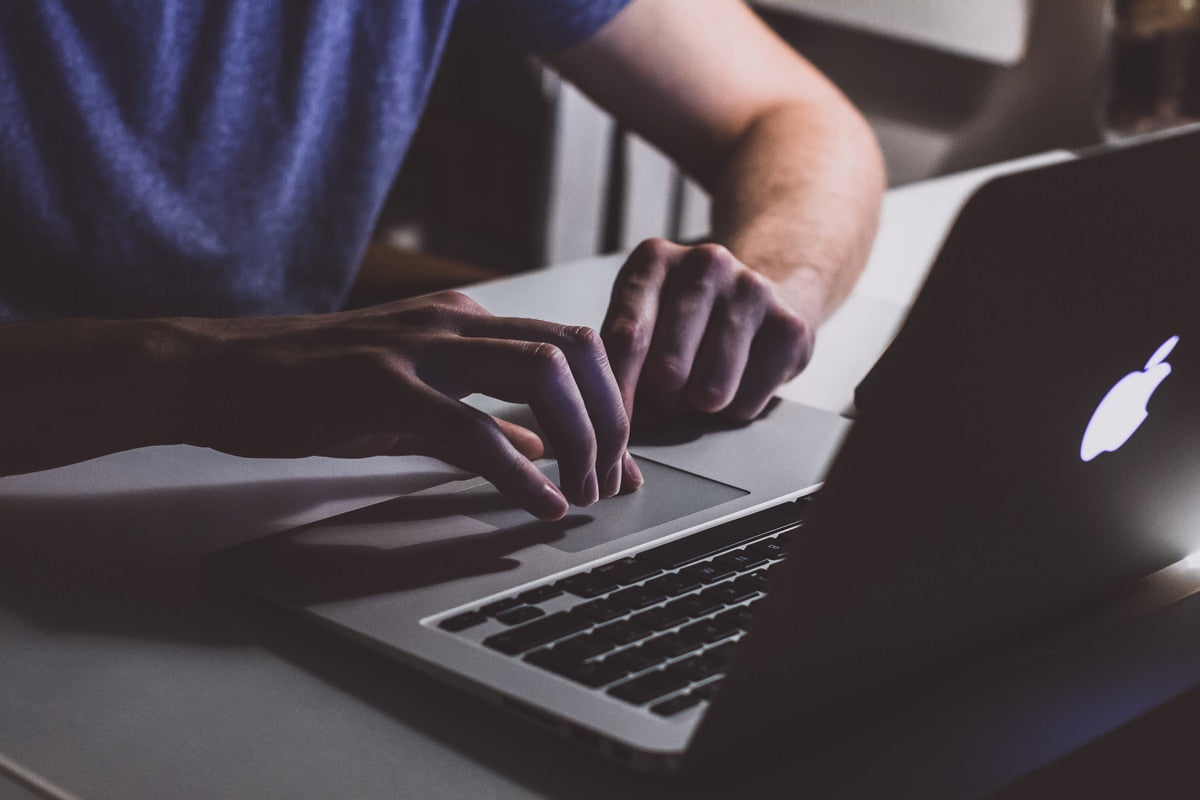 hands using laptop trackpad