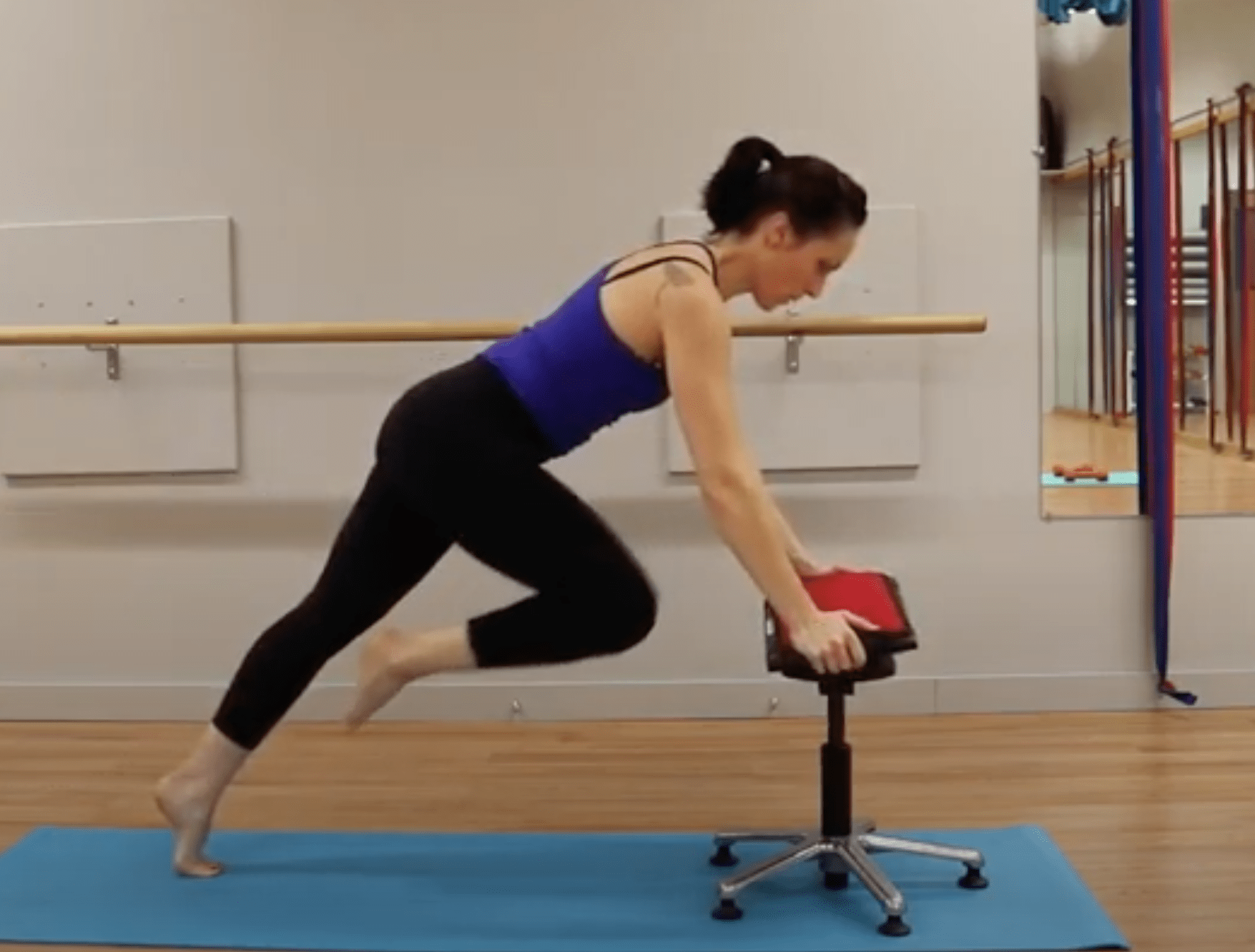 woman demonstrates exercise using QOR360 chair