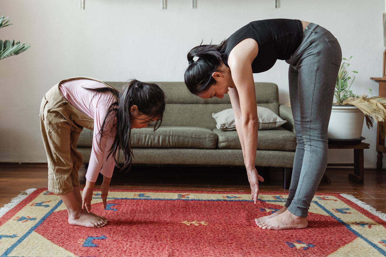 mom and daughter practicing yoga to stay active